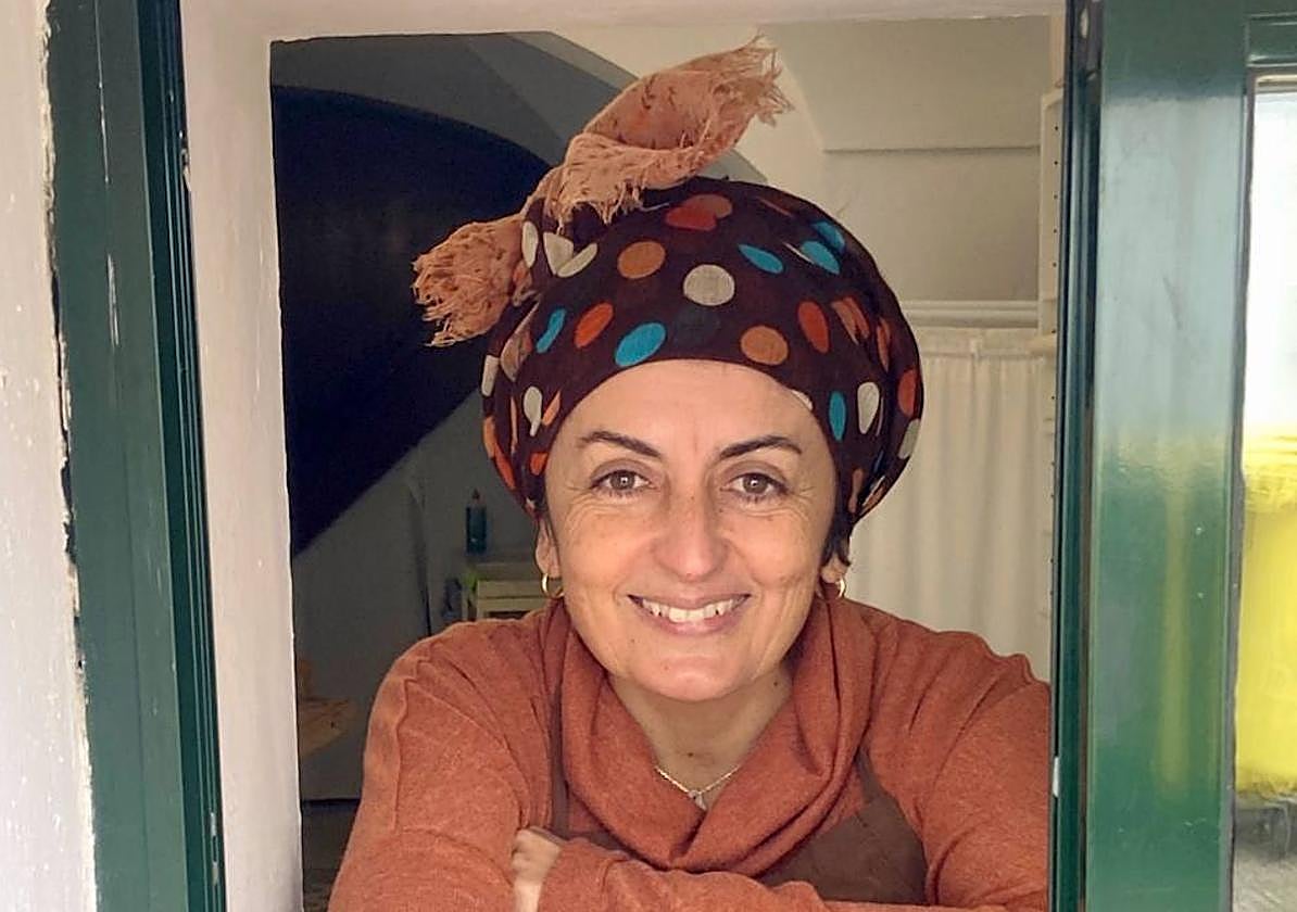 Remedios asomada a la ventana por la que despacha .