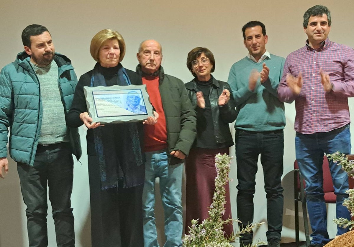 Ana, viuda de Diego, sostiene una placa de reconocimiento a su marido, en presencia de sus tres hijos, un cuñado y una sobrina, el sábado, en la Casa de la Cultura de Salvatierra.