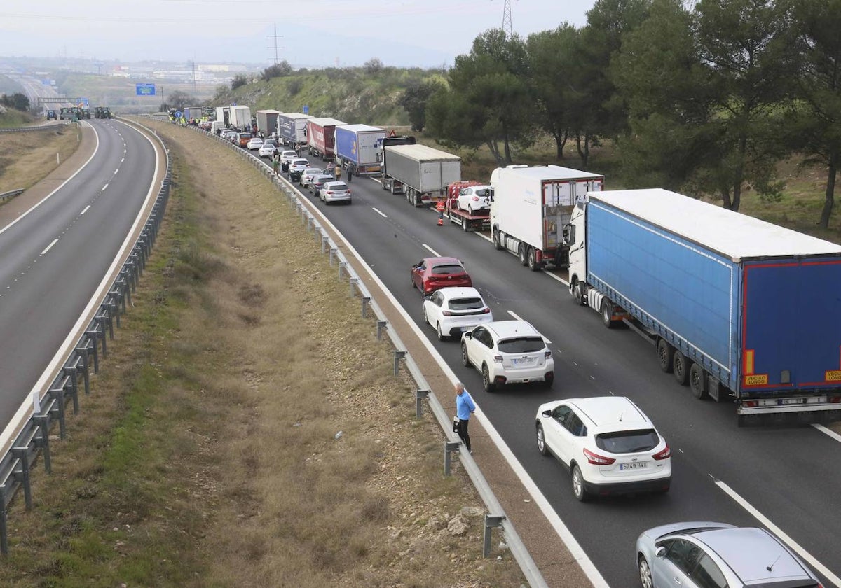 Vehículos retenidos en la confluencia de la A-5 con la A-66 en Mérida. Al fondo, tanto a la derecha como a la izquierda, tractores sobre la vía.