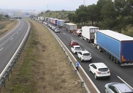 Vehículos retenidos en la confluencia de la A-5 con la A-66 en Mérida. Al fondo, tanto a la derecha como a la izquierda, tractores sobre la vía.