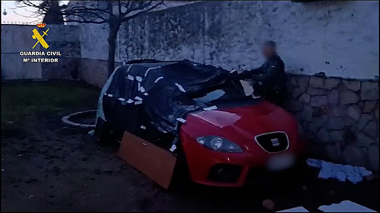 Imagen del coche robado, cubierto, en el patio de una vivienda de Madrigalejo.