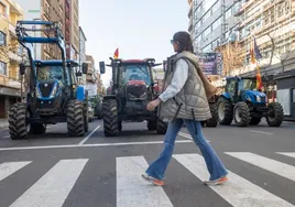 Una mujer cruza por un paso de peatones durante la protesta de agricultores en Cáceres.