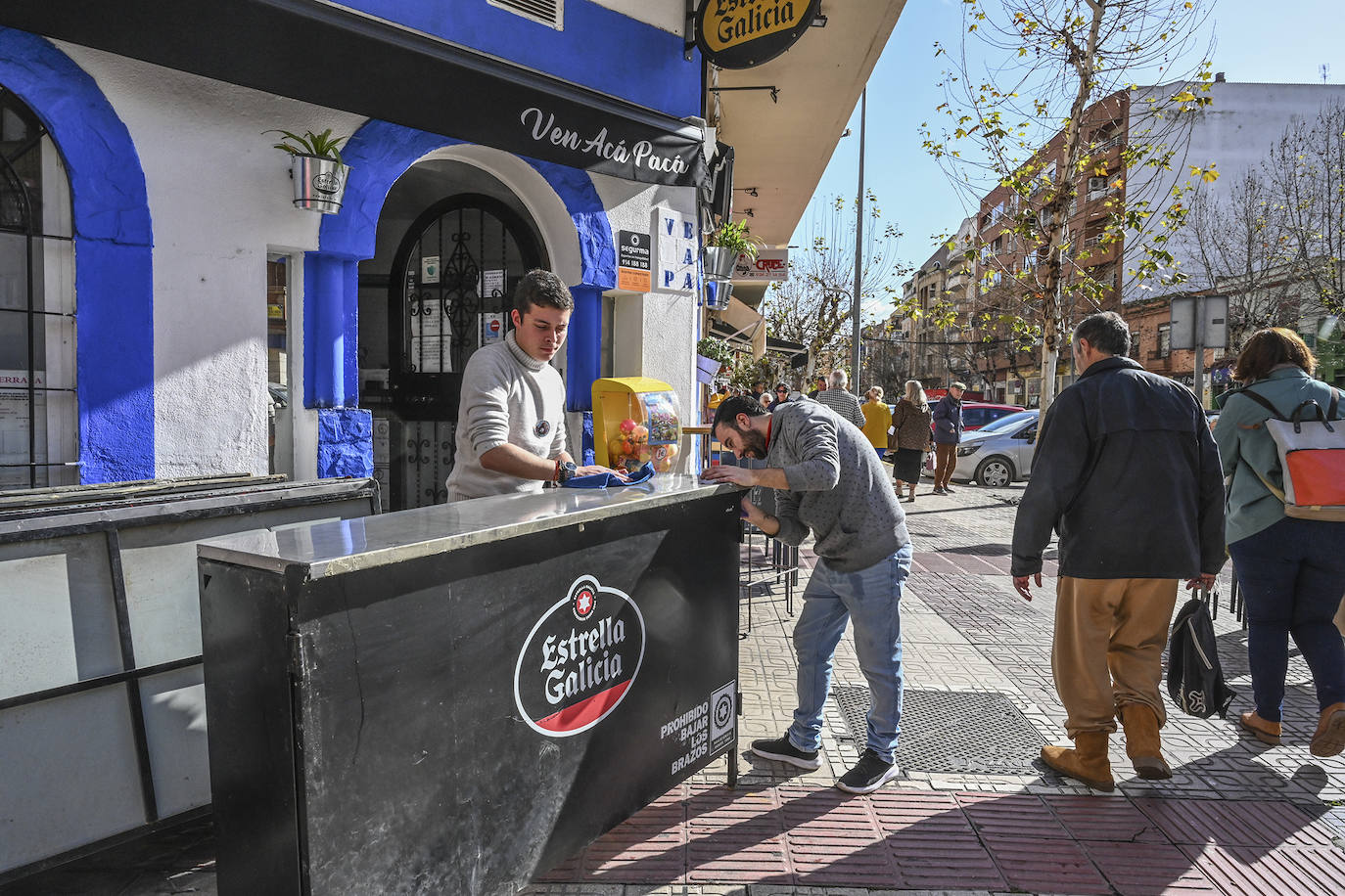 Diego Semedo coloca con ayuda de Alberto la barra en la calle para celebrar el entierro de las sardinas en San Roque del Carnaval de Badajoz