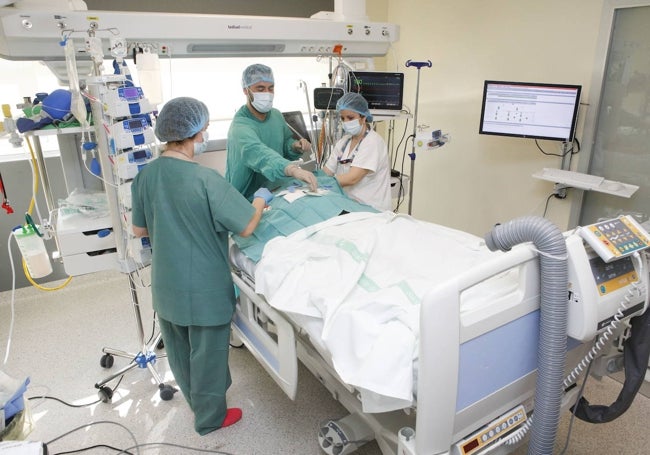 Sanitarios durante una intervención en la UCI del Hospital Universitario de Cáceres utilizando una innovador programa informático para monitorizar a los pacientes.