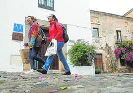 Dos viandantes pasan delante de un apartamento turístico situado en la calle Rincón de la Monja.