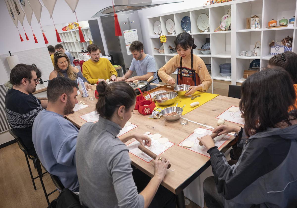 Imagen principal - Momentos del taller de elaboración de jiaozi.