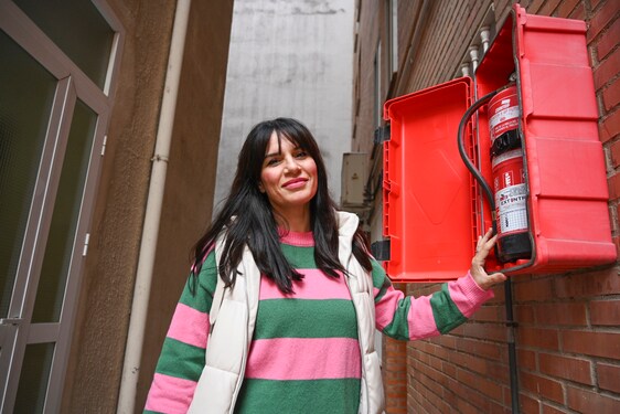 Davinia Granero junto a un extintor de su edificio, donde desea instalar detectores de humo.