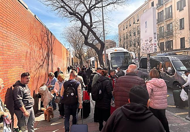 Pasajeros del Media Distancia Madrid-Sevilla a la espera de subir a un autobús.