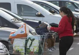 Una mujer y su hijo después de realizar la compra en un supermercado.