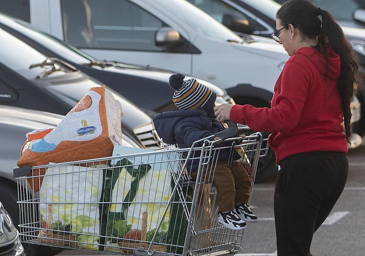 Una mujer y su hijo después de realizar la compra en un supermercado.