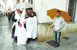 Cofrades de los Estudiantes se refugian de la lluvia.