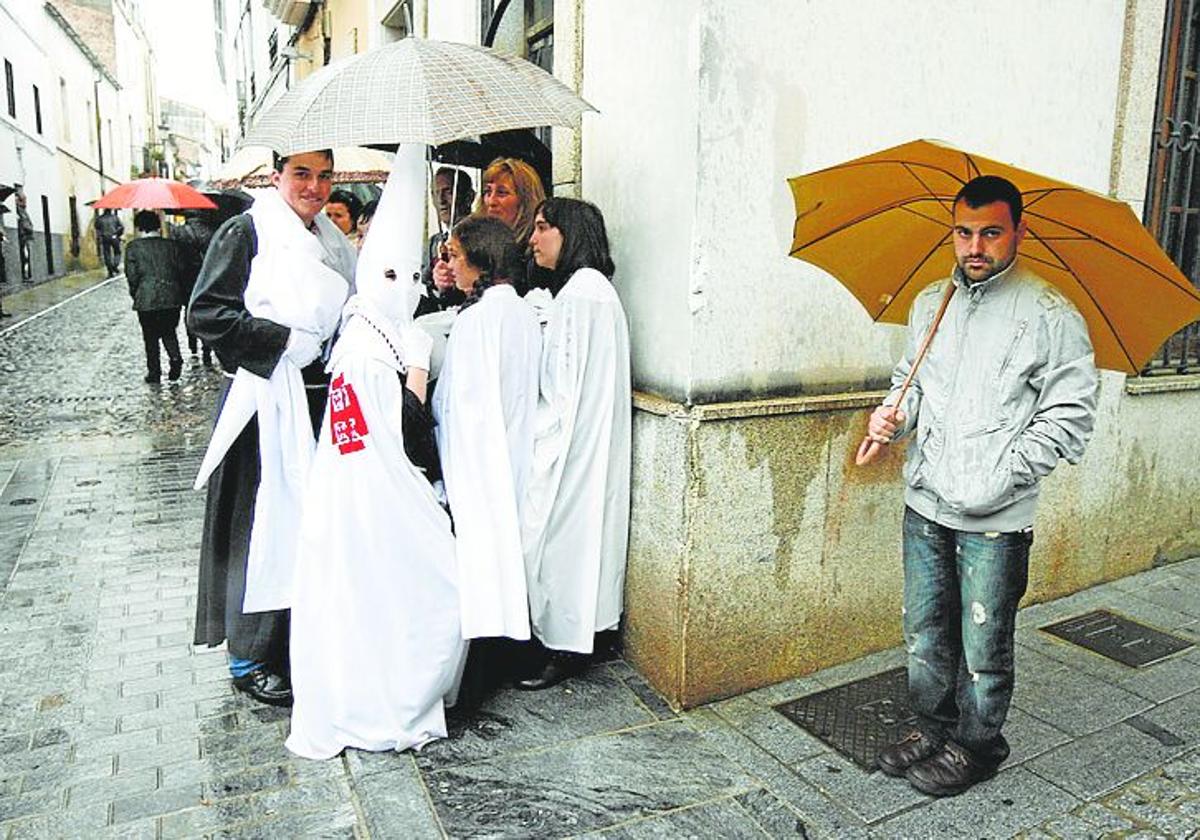 Cofrades de los Estudiantes se refugian de la lluvia.