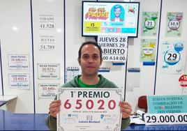 Diego Marín sostiene el cartel con el número premiado.