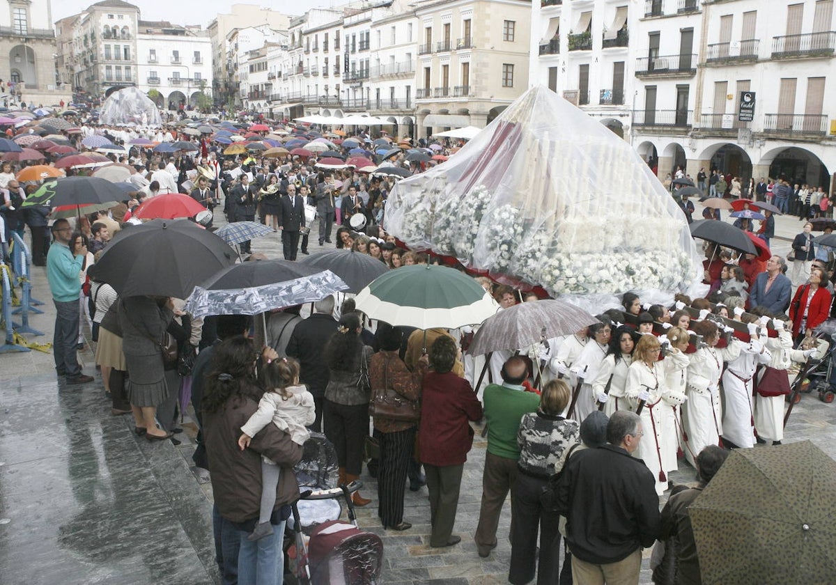 Pasos de la cofradía cacereña de la Sagrada Cena cubiertos con plástico en el Jueves Santo de 2011 por la Plaza Mayor.