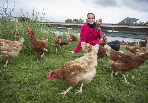 Itziar Amor, reconvertida granjera, junto a sus gallinas en la granja Con un Par, en Herreruela.