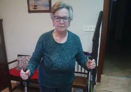 Isabel Iglesias, en su casa, con los dos bastones que utiliza diariamente para poder andar.