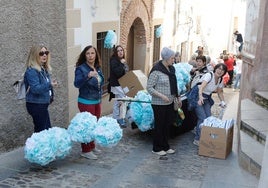 Vecinos engalanando la calle Caleros este martes para el paso de la Virgen de la Montaña.