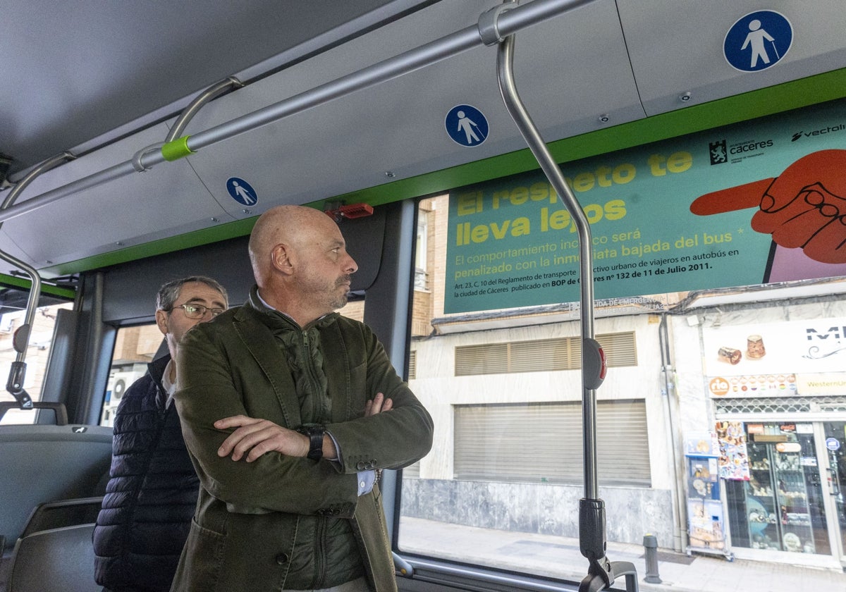 El concejal Pedro Muriel observa uno de los carteles colocados en el interior de los vehículos.