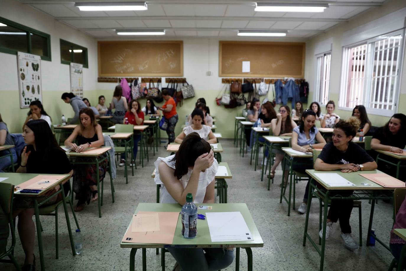 Aspirantes esperan a entrar en el aula en unas oposiciones.