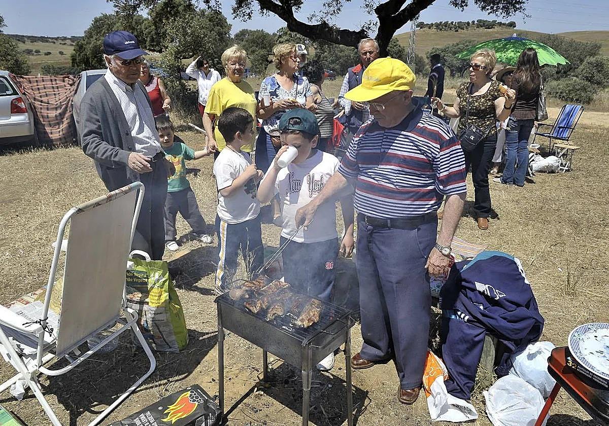 Familiares y amigos en torno a una barbacoa en una romería extremeña.