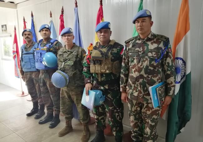 Madera González, delante de la bandera española, junto a otros militares destinados en Líbano.