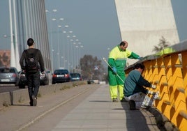 Operarios municipales pintan la barandilla del Puente Real en febrero de 2009