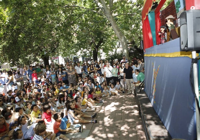 Niños en el Paseo de Cánovas para seguir un espectáculo de marionetas.