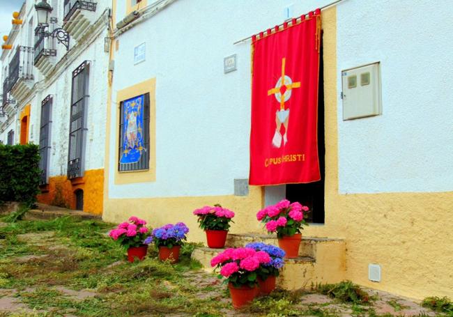 Una calle de Helechosa adornada con flores y colchas.