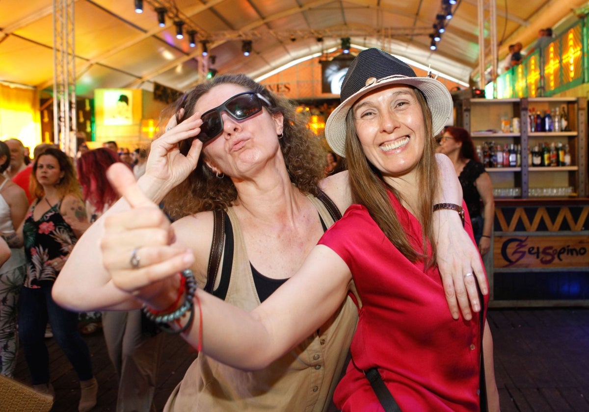 Dos mujeres disfrutan de la fiesta en una caseta del Recinto Ferial.