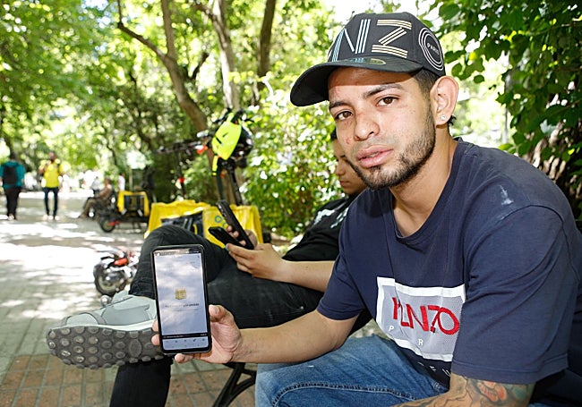 Los riders de Cánovas esperan a recibir pedidos en sus teléfonos móviles.