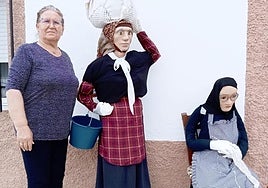 Francisca Cordero, junto a los dos mastros que ha elaborado y que ha expuesto en la puerta de su casa en la calle Libertad.