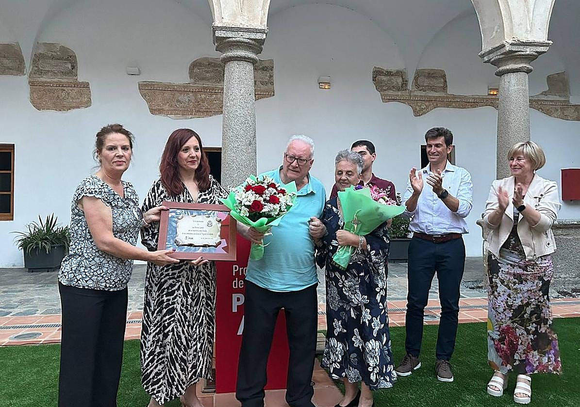 El homanejado, junto a su mujer, durante la entrega de placas y ramos de flores.