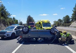 Bomberos trabajando en el lugar del accidente para excarcelar al joven que había quedado atrapado en el coche implicado en el accidente.