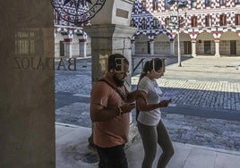 Dos personas pasan por la Plaza Alta junto a la sede de la UNED.