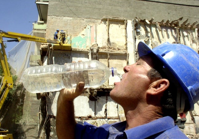 Un trabajador se refresca en Cáceres.