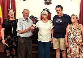 Mienbros de la Directiva de la ACT entregan un obsequio al socio de mayor edad