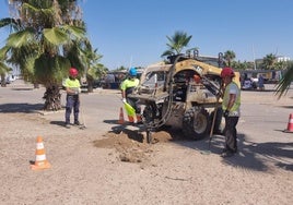 Los operarios poniendo los postes para el tendido eléctrico.