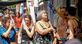 Los vendedores refrescan a los clientes con agua y ventiladores de mano para ayudarles a comprar con calor.