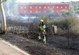 Uno de los bomberos durante su intervención. Al fondo, de color rojo, parte trasera del hotel AHC, que no se ha visto afectado por las llamas.