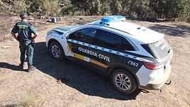 Agentes de la Guardia Civil junto a vehículo oficial.