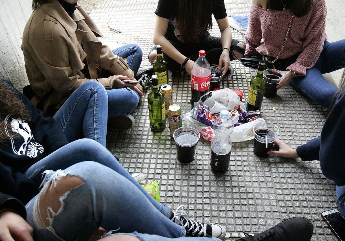 Unos adolescentes hacen botellón.