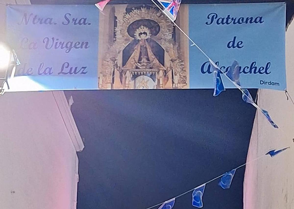 Imagen secundaria 1 - Arriba, componentes del Coro de Nuestra Señora de los Santos de Táliga, que amenizarán con la misa extremeña la eucaristía de este 15 de agosto. Abajo, lona de las fiestas patronales y merchandising que pone en venta la Hermandad de la Virgen de la Luz.