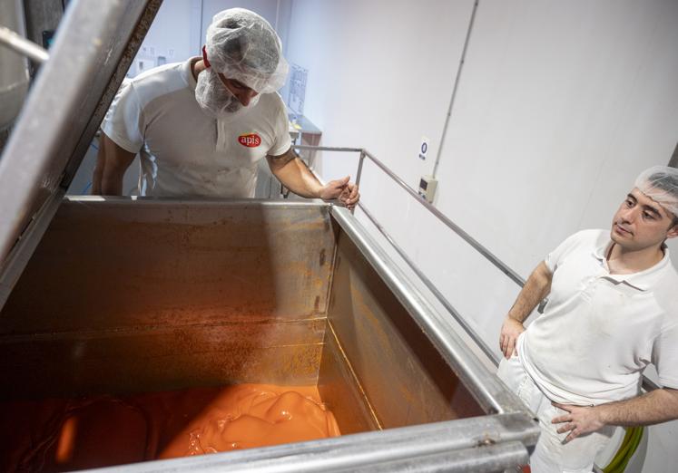 Trabajadores controlando el tomate frito en la mezcladora.