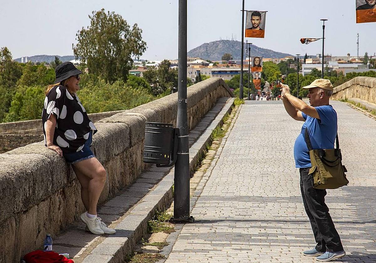 Una mujer es fotografiada en el puente Romano de Mérida.