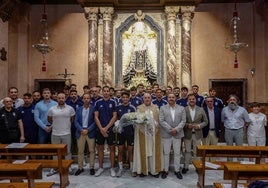 La plantilla del Badajoz junto al capellán del club Valeriano Domínguez en la ofrenda floral.