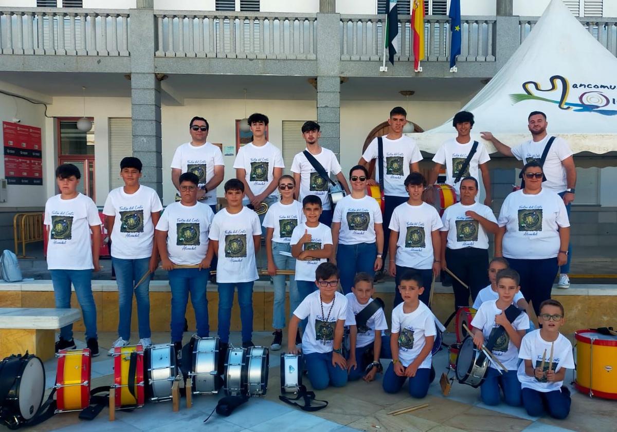 Imagen principal - Arriba, componentes de la Banda de Cornetas y Tambores 'Villa de Alconchel' tras la diana floreada que han dado este sábado. Abajo, a la izquierda, grupo de mujeres de la Asociación 'La Esperanza' y de la Hermandad del Cristo, durante la elaboración de dulces. A la derecha, ejemplares del libro de fiestas del Cristo 2024.