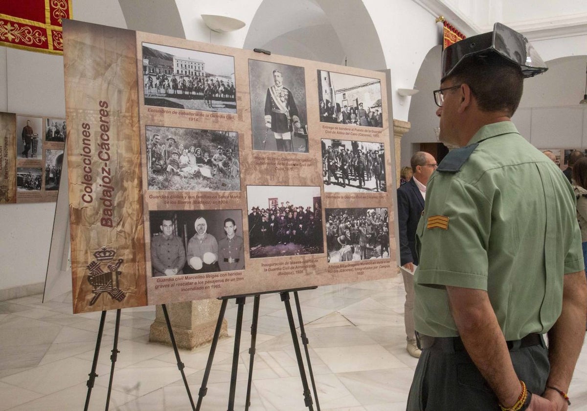 Un miembro de la Guardia Civil observa varias fotografías de la muestra.