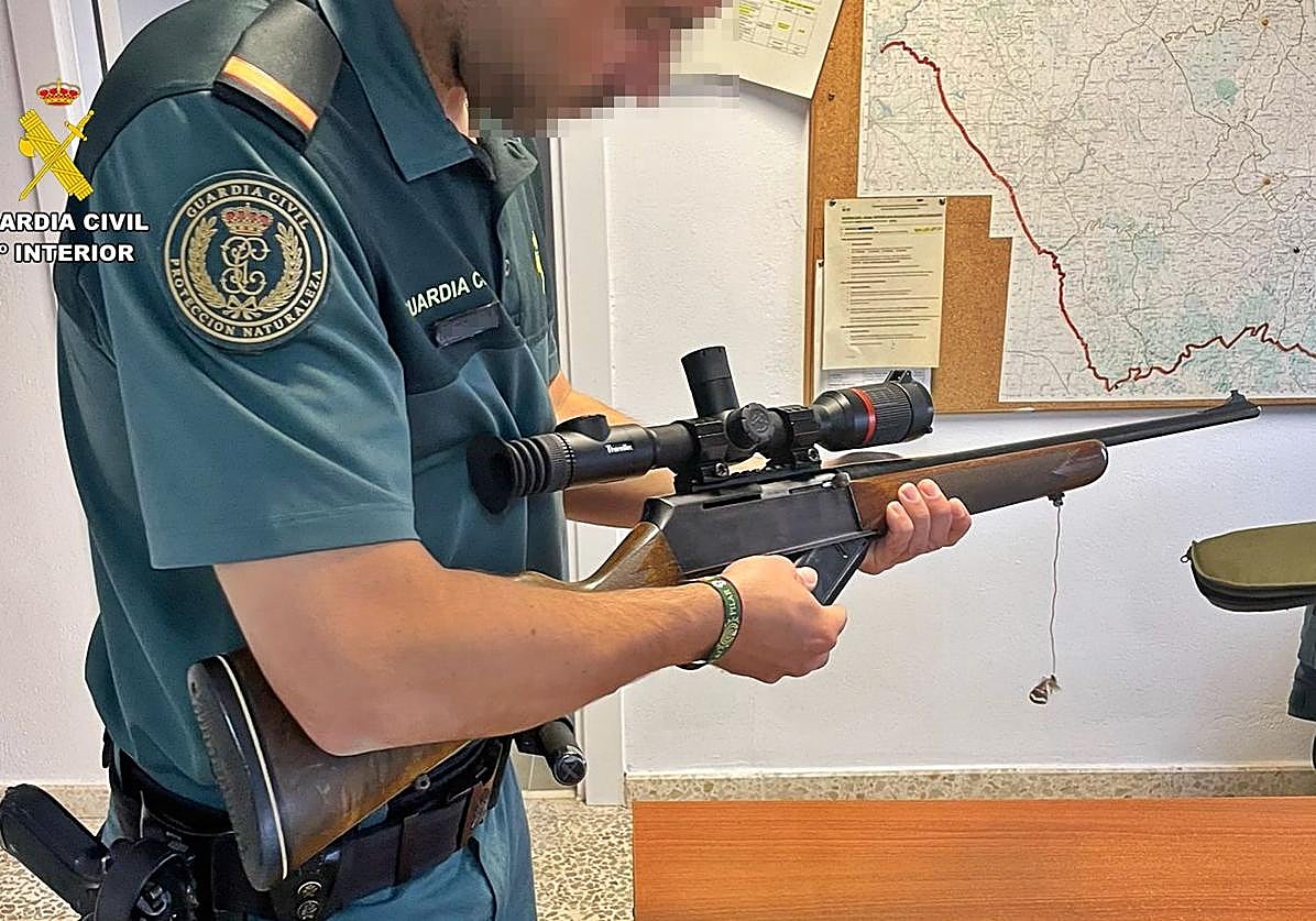 Un agente del Seprona con el rifle municionado intervenido.
