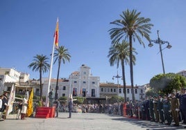 Izado de la bandera nacional durante el himno en la Plaza de España de Mérida.