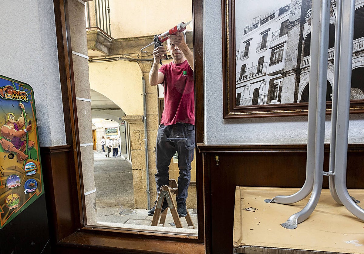 Un trabajador sustituye el ventanal del Bar Torero destrozado en el robo de esta madrugada.